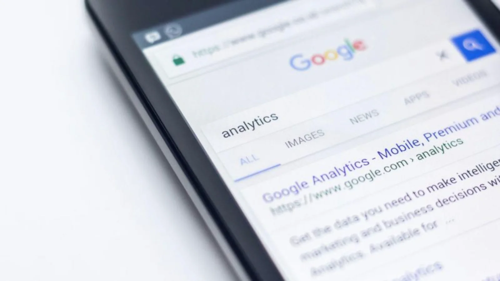 A imagem é um close em ângulo inclinado da tela de um smartphone exibindo a página de resultados de busca do Google.